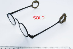 008a Iron round eye spectacles with short straight sides ending in cloth covered ring ends. Surface rust, no damage, original lenses. Members £25 (non members £30) plus postage. SOLD